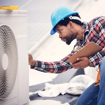 A worker inspecting a HVAC system