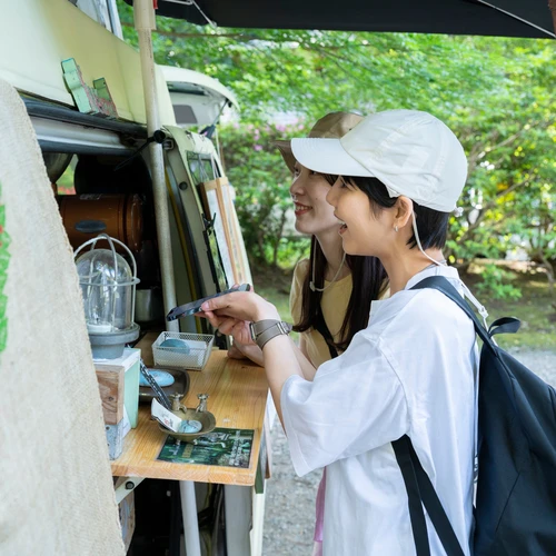 Two Women Ordering Food And Drink From A Catering Business