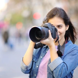 A female student taking a photo with their camera