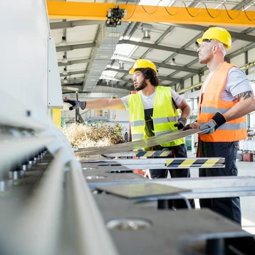 Two workers manufacturing sheet metal