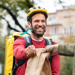 A Food Deliverer Passing Food To A Customer