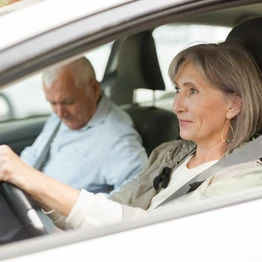 A Driver Over The Age Of 50 In Their Car With A Passenger